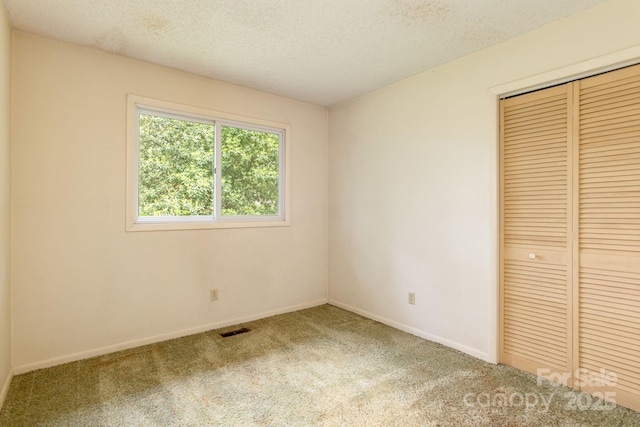 6 N Hudson Ln, Fletcher, NC 28732 - unfurnished bedroom with carpet floors, a closet, baseboards, and a textured ceiling