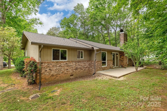 6 N Hudson Ln, Fletcher, NC 28732 - back of house with a patio area, brick siding, a chimney, roof with shingles, and a lawn