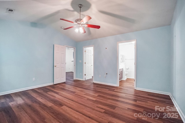 unfurnished bedroom featuring wood finished floors, baseboards, vaulted ceiling, ensuite bathroom, and a ceiling fan