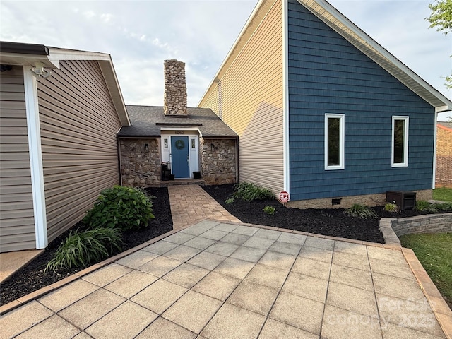 exterior space with a patio, crawl space, and a chimney