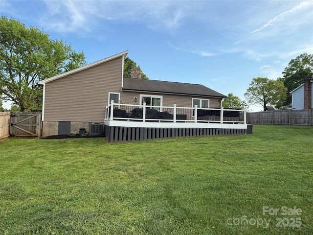 rear view of house with a fenced backyard, cooling unit, a gate, a wooden deck, and a lawn