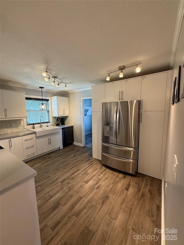 kitchen with a sink, dark wood-style flooring, white cabinetry, stainless steel refrigerator with ice dispenser, and track lighting