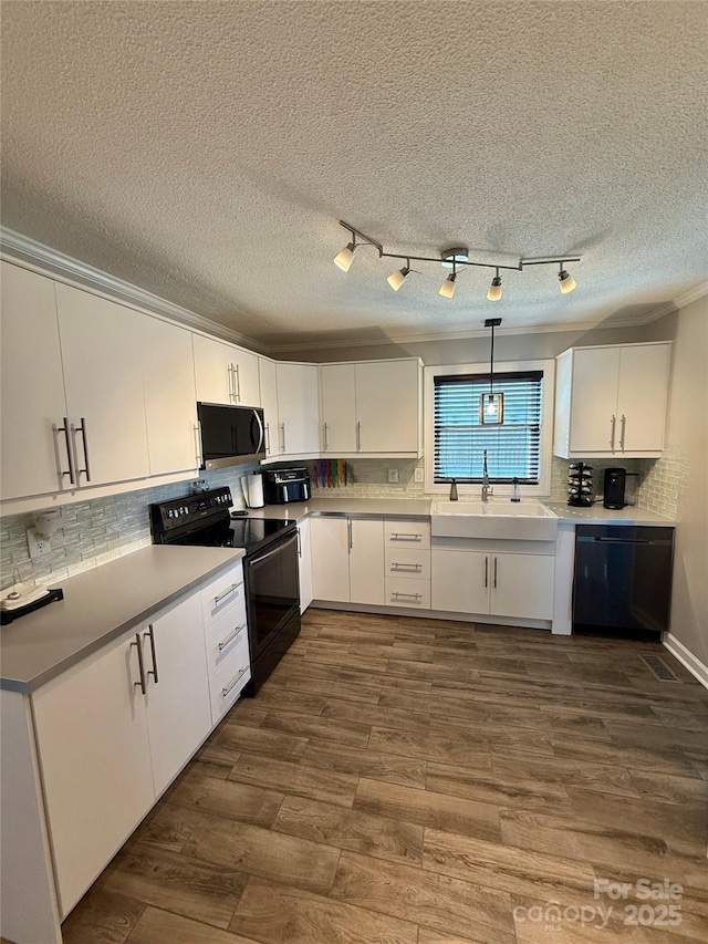 kitchen featuring backsplash, a sink, white cabinetry, and black appliances