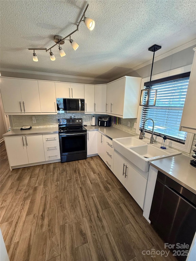 kitchen with a textured ceiling, stainless steel microwave, tasteful backsplash, and black electric range