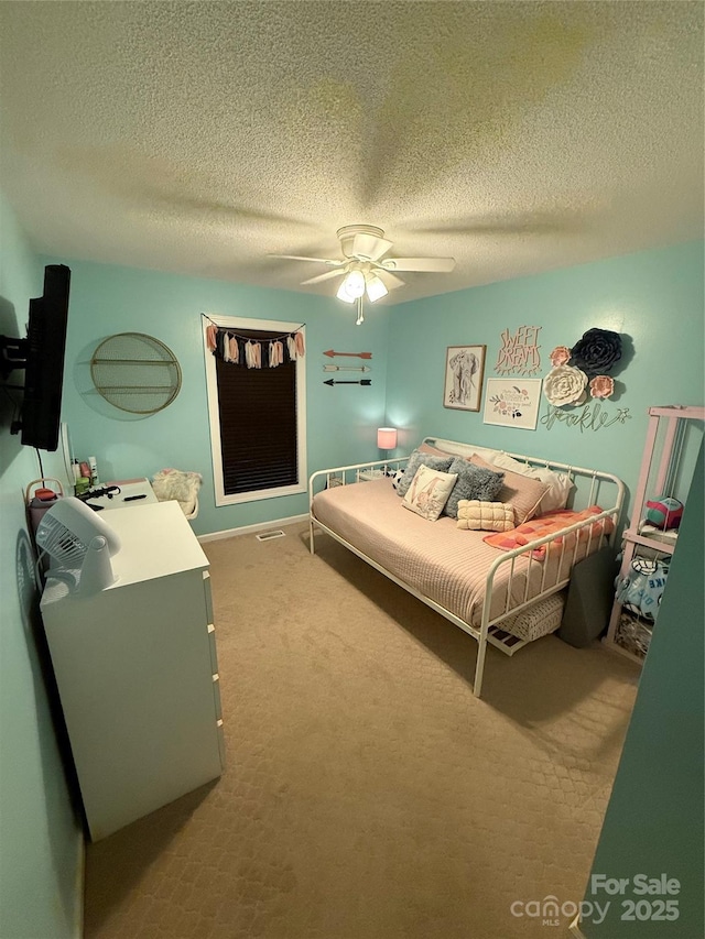 carpeted bedroom featuring a textured ceiling and ceiling fan