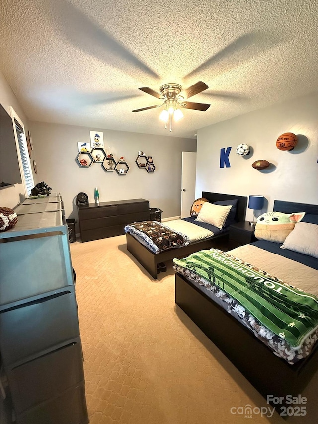 bedroom with carpet, a ceiling fan, and a textured ceiling