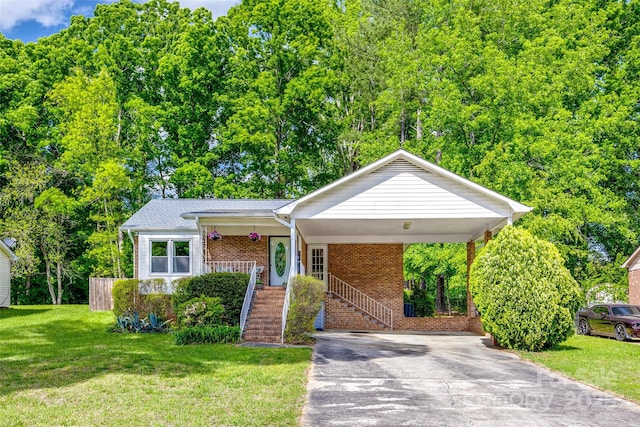 ranch-style house featuring stairs, driveway, an attached carport, brick siding, and a front yard
