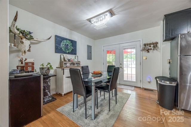 dining room featuring visible vents, light wood-style flooring, electric panel, and french doors