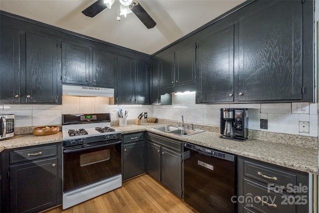 kitchen featuring under cabinet range hood, range with gas cooktop, a sink, decorative backsplash, and black dishwasher