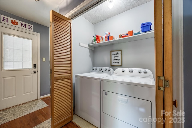 washroom featuring separate washer and dryer, wood finished floors, a textured ceiling, and laundry area