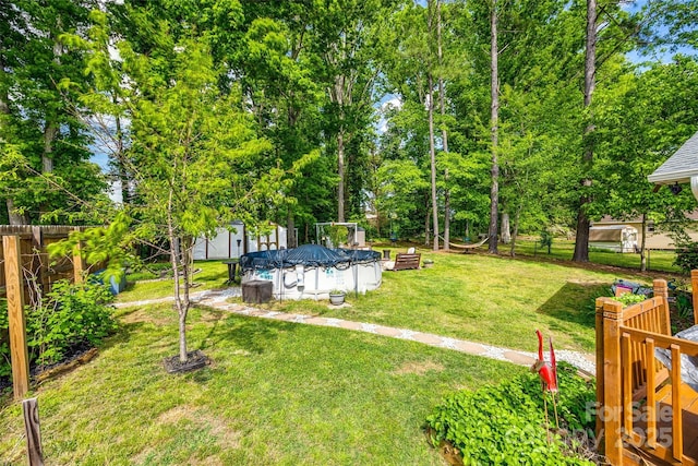 view of yard with a fenced backyard and a covered pool