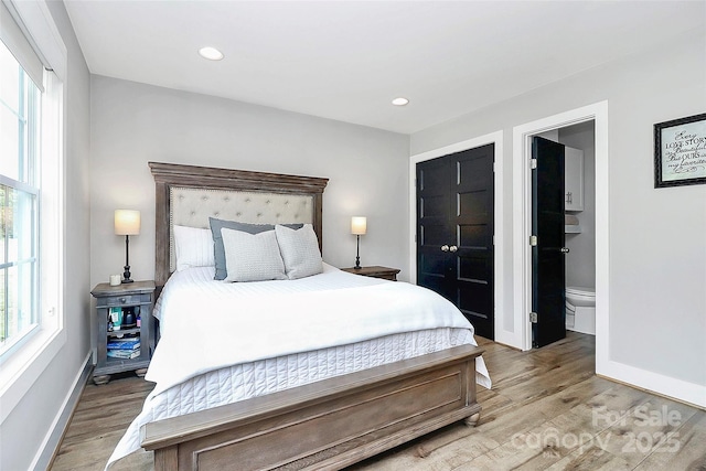 bedroom featuring baseboards, recessed lighting, light wood finished floors, and connected bathroom