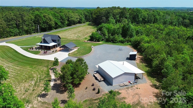birds eye view of property with a view of trees and a rural view