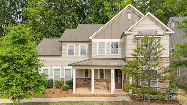 craftsman-style house featuring board and batten siding, stone siding, a standing seam roof, and covered porch
