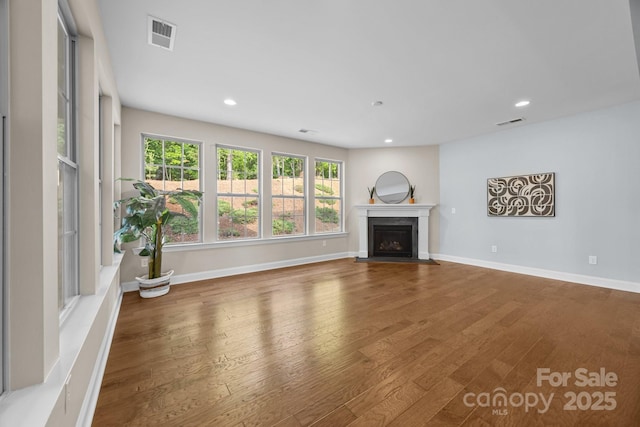 unfurnished living room with a fireplace with flush hearth, wood finished floors, visible vents, and recessed lighting