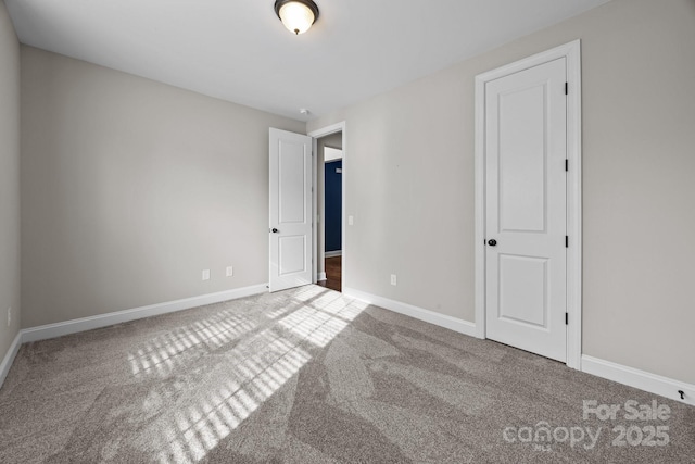 unfurnished bedroom featuring carpet and baseboards