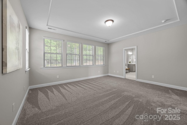 carpeted empty room featuring baseboards and visible vents