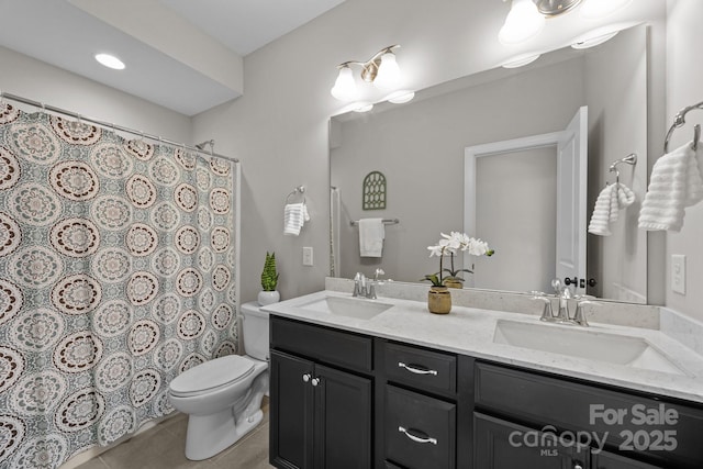 full bath featuring toilet, tile patterned floors, a sink, and double vanity