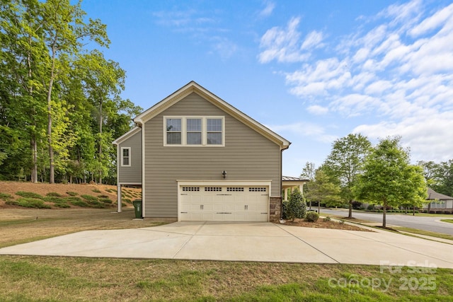 view of property exterior featuring driveway, stone siding, and a garage
