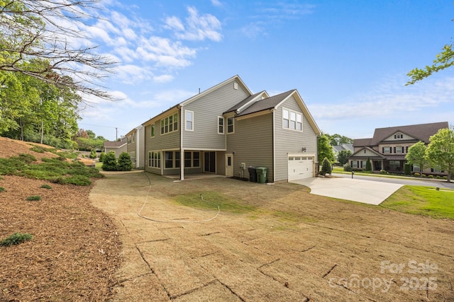 rear view of house featuring an attached garage and driveway