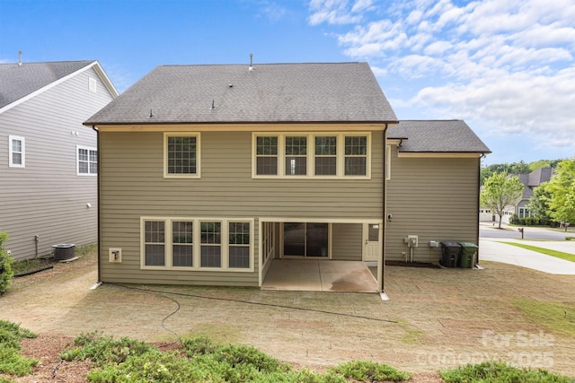 back of property with roof with shingles, a patio, and central AC unit