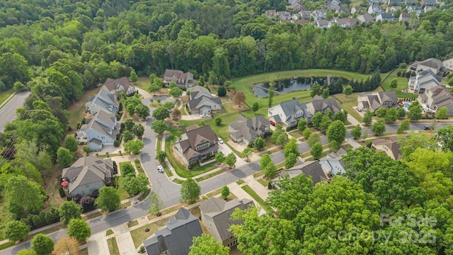 bird's eye view featuring a forest view, a residential view, and a water view