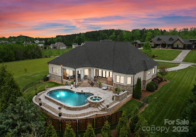 767 Pinnacle Dr, Iron Station, NC 28080 - pool at dusk with a patio, a fenced backyard, a lawn, and a pool with connected hot tub