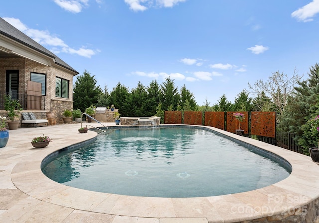 767 Pinnacle Dr, Iron Station, NC 28080 - view of swimming pool with fence, a pool with connected hot tub, and a patio area