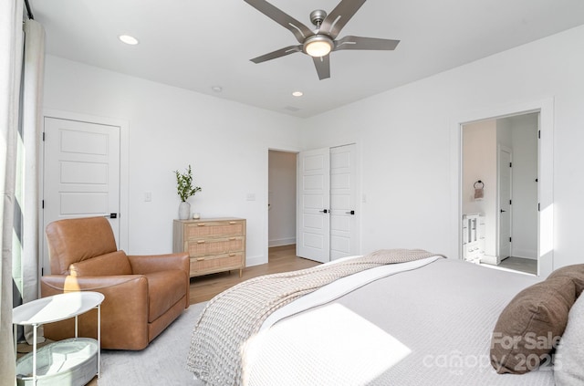 bedroom featuring a ceiling fan, recessed lighting, light wood-style flooring, and connected bathroom