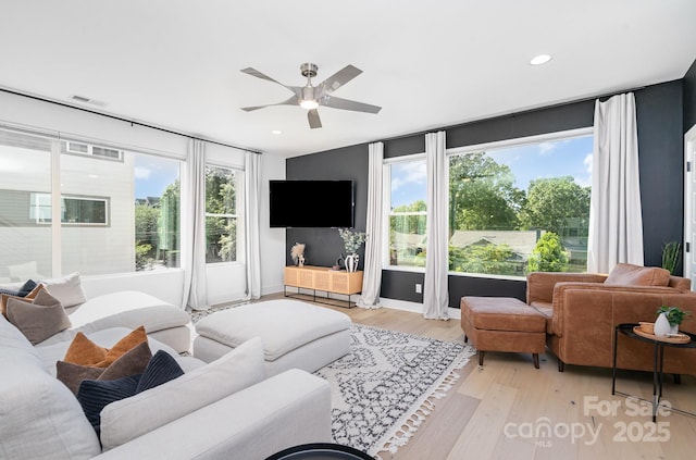 living area featuring ceiling fan, visible vents, baseboards, light wood-style floors, and recessed lighting