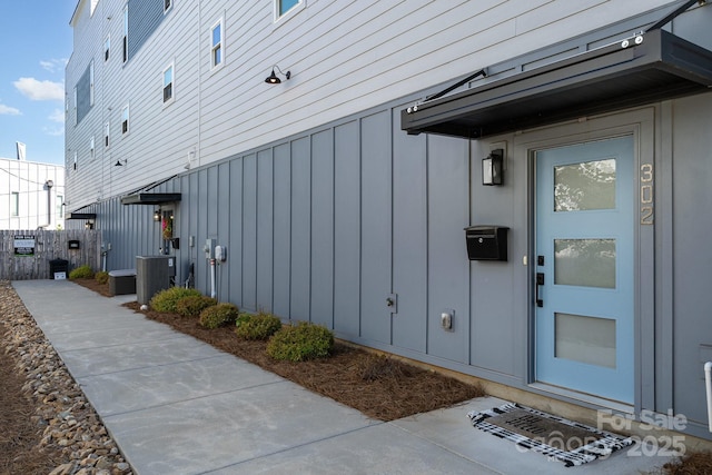 doorway to property featuring central AC unit and board and batten siding