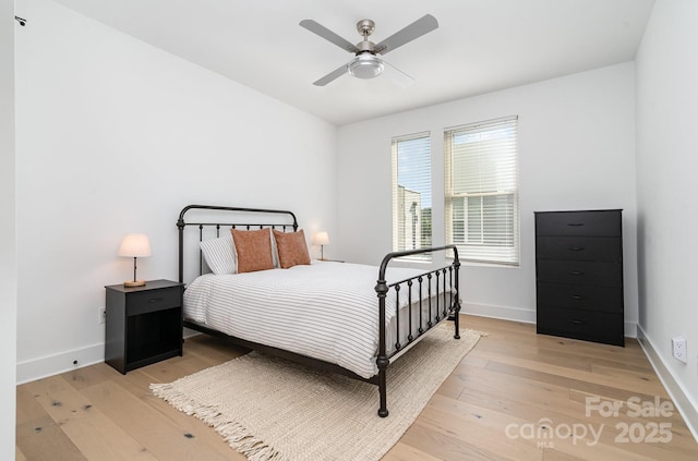bedroom with light wood-type flooring, baseboards, and ceiling fan