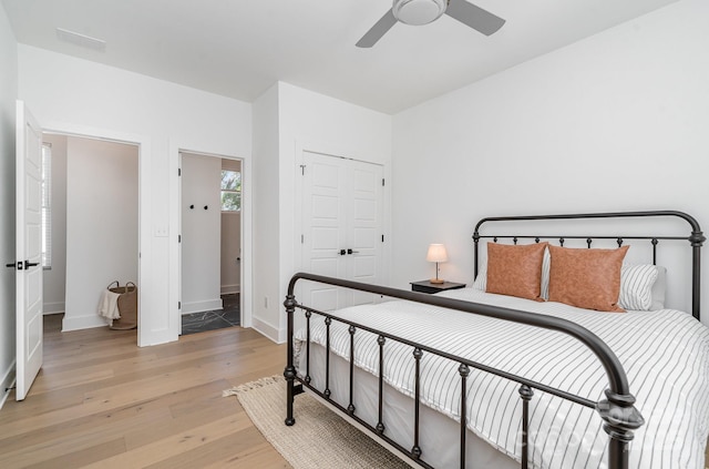 bedroom with a closet, baseboards, ceiling fan, and light wood-type flooring