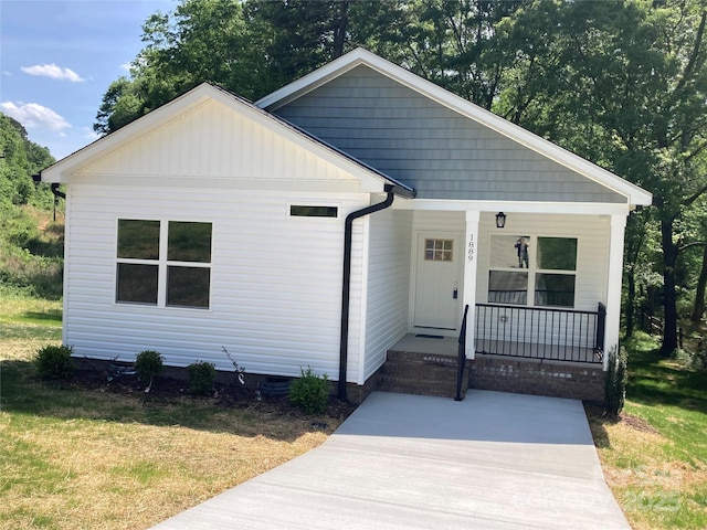 bungalow featuring a front yard and covered porch