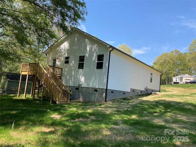 back of house featuring a lawn, crawl space, a deck, and stairway