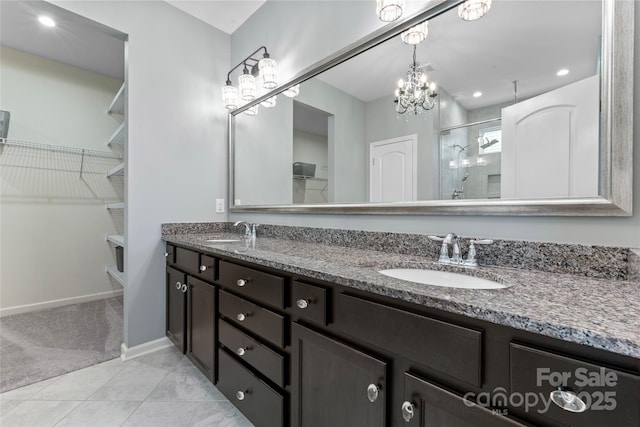 2124 Katie Alice Cir, Waxhaw, NC 28173 - full bath with a stall shower, double vanity, a walk in closet, baseboards, and a chandelier