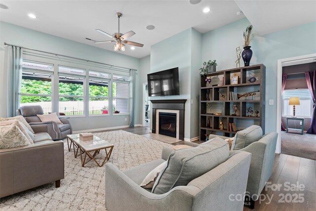 2124 Katie Alice Cir, Waxhaw, NC 28173 - living room with wood finished floors, a ceiling fan, a glass covered fireplace, and recessed lighting