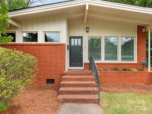 entrance to property featuring brick siding, visible vents, and crawl space