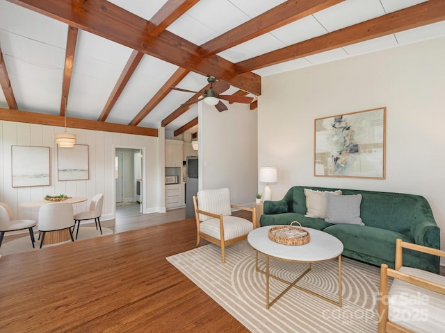 living room with ceiling fan, baseboards, wood finished floors, and vaulted ceiling with beams