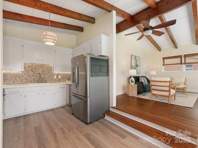 kitchen featuring baseboards, a ceiling fan, light wood finished floors, and stainless steel fridge