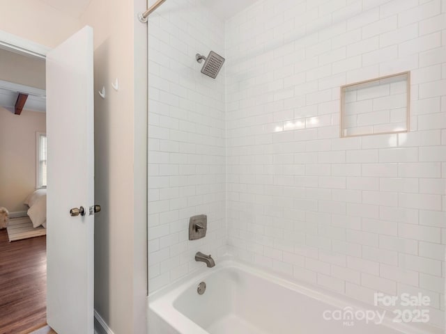 ensuite bathroom featuring wood finished floors, connected bathroom, baseboards, and  shower combination