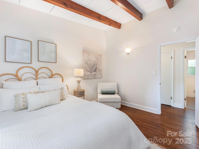 bedroom featuring baseboards, wood finished floors, and beam ceiling