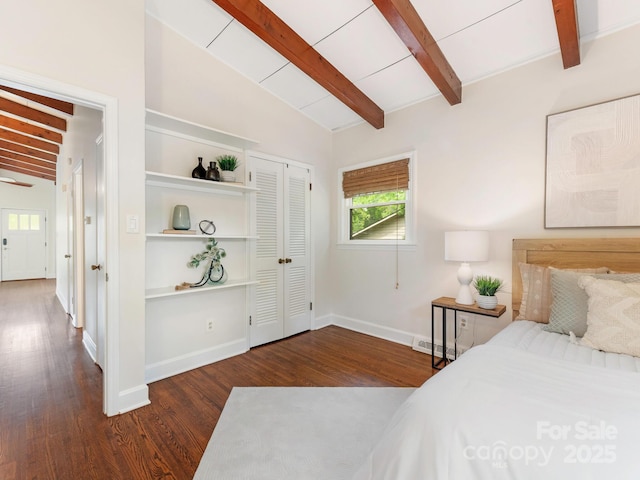 bedroom with wood finished floors, visible vents, vaulted ceiling with beams, and baseboards