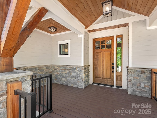 entrance to property with covered porch and stone siding