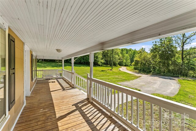 wooden deck with a yard and a porch
