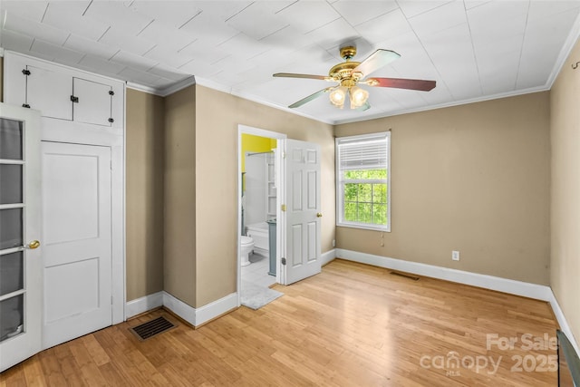 unfurnished bedroom with baseboards, visible vents, ornamental molding, and light wood-style floors