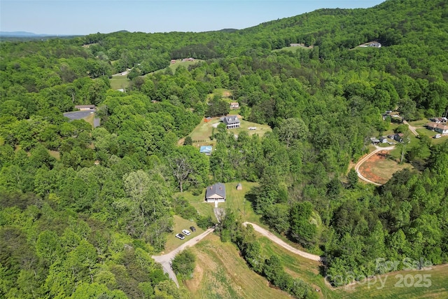birds eye view of property featuring a view of trees