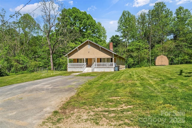 3181 Fay Lowman Rd, Connelly Springs, NC 28612 - view of front of property featuring a storage shed, a front lawn, covered porch, and a chimney