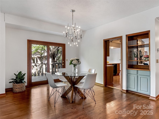 3 Governors Dr, Asheville, NC 28804 - dining area featuring an inviting chandelier, a textured ceiling, dark wood-style flooring, and baseboards