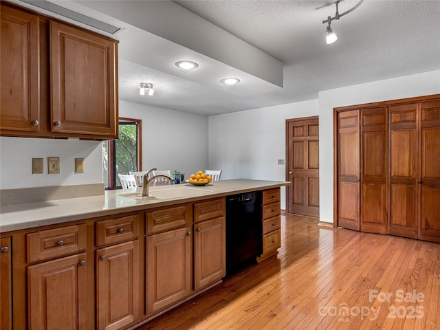 3 Governors Dr, Asheville, NC 28804 - kitchen featuring brown cabinetry, a peninsula, a textured ceiling, a sink, and dishwasher